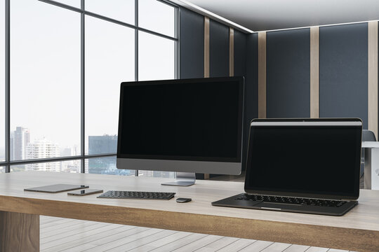 Luxury designer office desktop with empty mock up computer screens, supplies and blurry interior with windows and city view background. 3D Rendering.