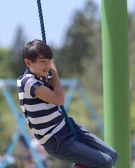 A young boy swinging on a rope