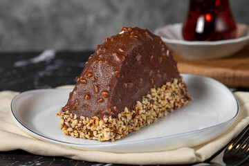 Banana and chocolate cream cake. Chocolate covered and hazelnut malaga cake on a dark background. Close up