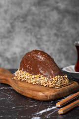 Banana and chocolate cream cake. Chocolate covered and hazelnut malaga cake on a dark background.