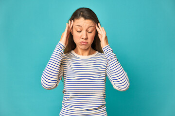 A young caucasian woman isolated touching temples and having headache.