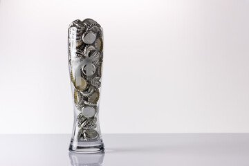 Stylized beer glass filled with beer bottle caps.