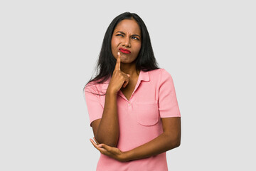 Obraz premium Young Indian woman cut out isolated on white background looking sideways with doubtful and skeptical expression.
