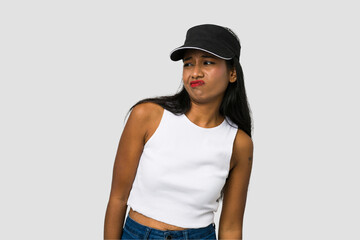 Young Indian woman cut out isolated on white background shrugs shoulders and open eyes confused.