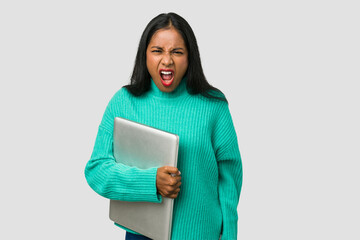 Young indian woman holding a laptop isolated on white background