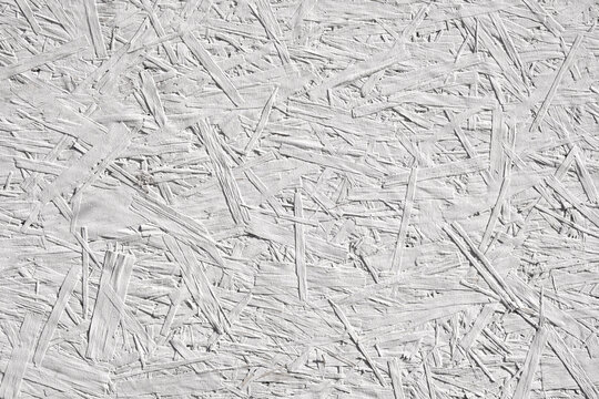 Abstract wooden background from a pressed sawdust panel painted white.