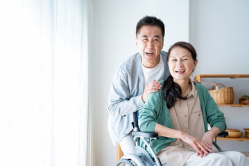 介護をする男性と車椅子に座る女性