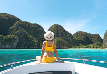 Rear view of tourist woman sit on the sailing boat luxury travel southeast asia on summer vacations Maya beach Ko Phi Phi - obrazy, fototapety, plakaty