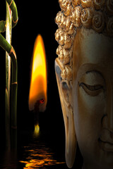 Lumière dans la nuit ; bougie, bambou et bouddha