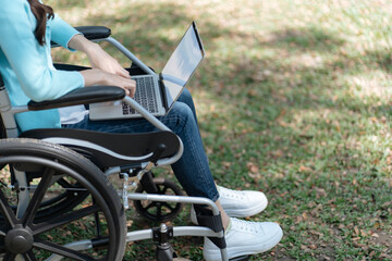 Young asian woman in wheelchair working with laptop