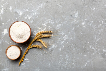 Flat lay of Wheat flour in wooden bowl with wheat spikelets on colored background. world wheat...