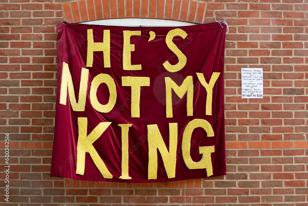 Wall mural opposition to king charles coronation. he's not my king banner on the side of a house with a hand wr