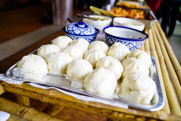 Steamed buns on tray on bamboo table ready to eat in the morning, asian food, side view