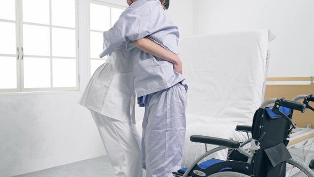 ベッドから車椅子へ移乗介助する介護士
