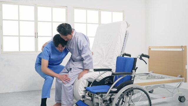 ベッドから車椅子へ移乗介助する介護士