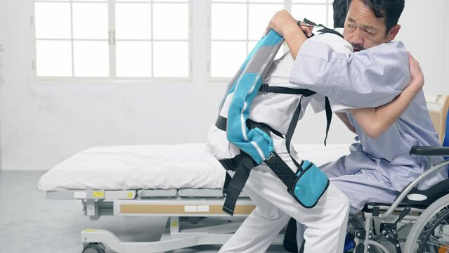 パワーアシストスーツをつけて患者を抱える看護師　移乗介助機器