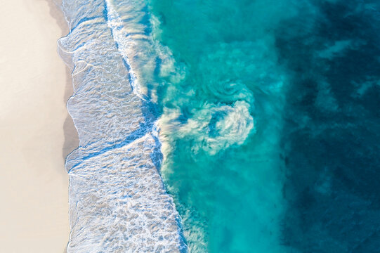 Aerial view of sandy beach with waves and riptide current. Sunny day in summer with transparent tropical blue water. Travel to Alkimos Beach, Western Australia, Australia. Top view. Coastal, Seascape