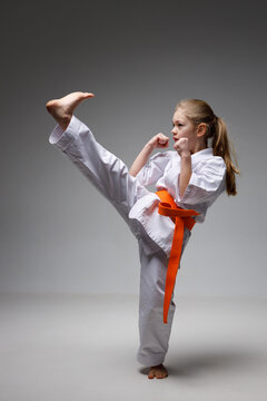 Kick and block in karate, little girl in training.