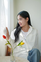 portrait photography woman.She wore a white shirt and looked out the window smiling happily.