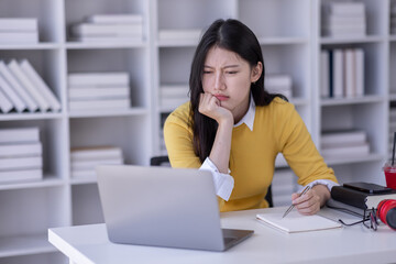 Young adult happy smiling Hispanic Asian student wearing headphones talking on online chat meeting using laptop in university campus or at virtual office. College female student learning remotely.
