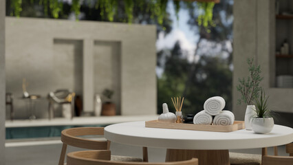 Set of spa accessories on a table over blurred background of a beautiful swimming pool.