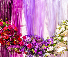 Beautiful backdrop flowers arrangement over purple fabric