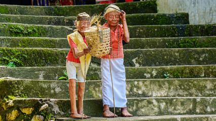 Carved statues of men and women holding bamboo bags placed on the stairs at the Londa tourist spot...