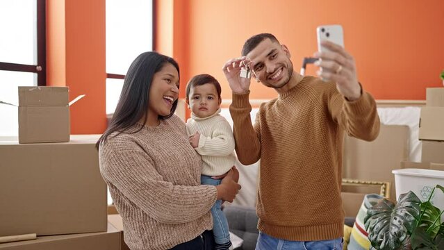 Couple and son make selfie by smartphone holding keys at new home
