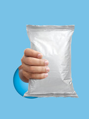 Foil food package mockup in hand on light blue background