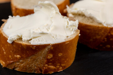 fresh soft cheese made from cow's milk spread on wheat bread
