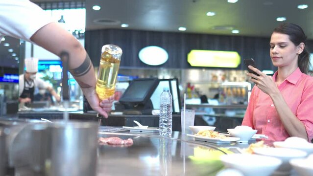Happy young woman enjoying foodie time and drink in restaurant.