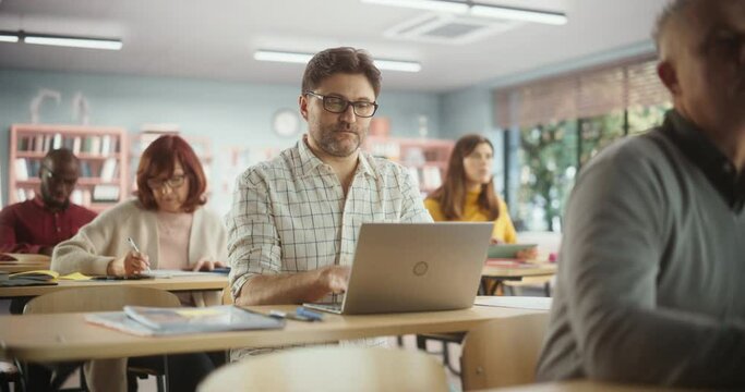 Middle Aged Man Studying in Classroom, Using Laptop to Write Down Lecture Notes. Group of People Taking a Workshop on Improving Professional Soft Skills. Adult Education Center Concept