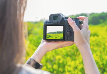 Woman tourist holding digital camera with taking photo on garden park, Summer time concept.