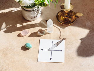 Rock crystal pendulum on the table. Stones and crystals for meditation and relaxing.