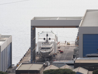 Super Yacht hauled out in shipyard, being lifted by industrial crane for refit or maintenance yard...