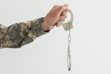 a military man is holding handcuffs
