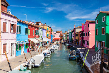 Fototapeta na wymiar Burano, Italy with colorful painted houses along canal with boats