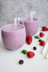 Cocktail with milk, ice cream and berries. On a white background. Deliciously