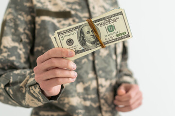 Army soldier holding money against white background