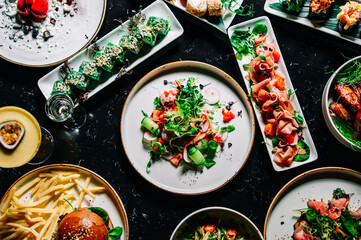 variety of restaurant food dishes on table. top view.
