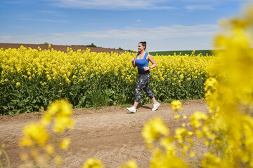 Plus size woman running on a countryside dirt road