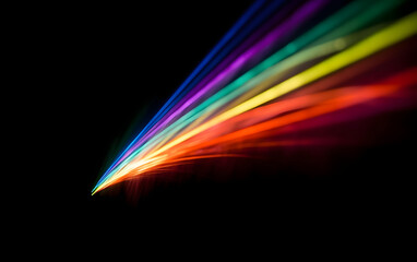 A striking visual of a light beam dispersing into a vibrant spectrum of colors against a stark black background, resembling a prism effect