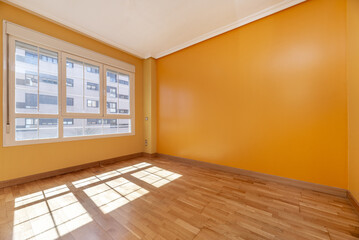 Empty room with oak floors, a large window