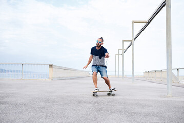 Fototapeta na wymiar Guy skateboarding on seafront