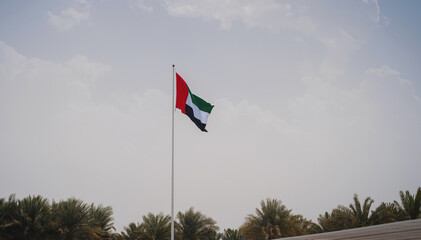 United Arab Emirates flag flying against sky. UAE celebrates it's national day on 2nd December every year.