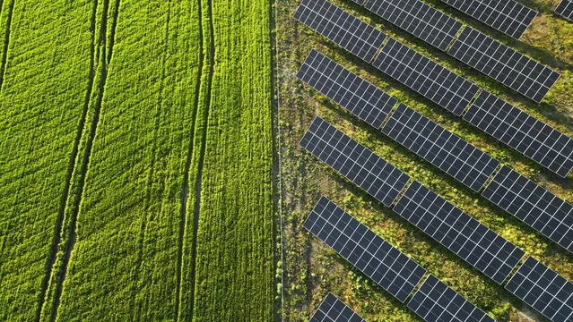 An aerial view of solar panels set amidst a desert landscape. The rugged terrain and clear blue skies provide a stunning backdrop for the panels, which stand as a beacon of hope in an otherwise harsh