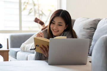 Naklejka premium Attractive young Asian woman sleep in the minimal and comfortable living room enjoying reading a book