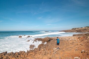 Explorer and hiker walk across the sandy terrain towards his destination in the Odemira region, western Portugal. Wandering along the Fisherman Trail, Rota Vicentina