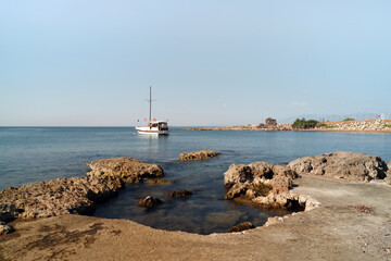 Fototapeta na wymiar A small yacht moored off the shore