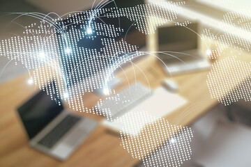 Double exposure of abstract digital world map with connections and modern desktop with laptop on background, research and strategy concept